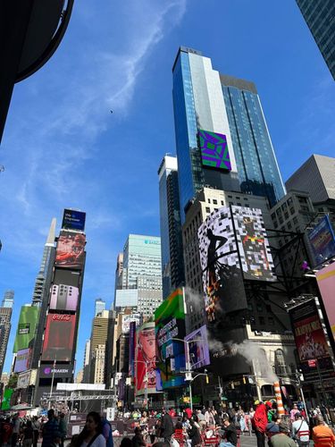 Skyscrapers in Times Square, New York City, with digital billboards and crowds below.